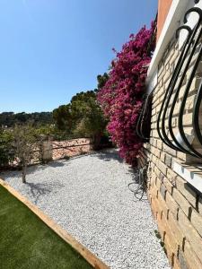a stone wall with purple flowers next to a building at T2 niché entre mer et montagne in Ollioules +4 photos