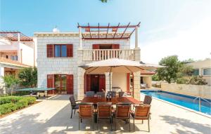 a table with chairs and an umbrella next to a pool at Holiday Home Pinji Vi in Zaton +48 photos