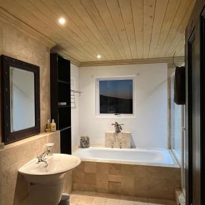 a bathroom with a tub and a sink at LaShack in Langebaan