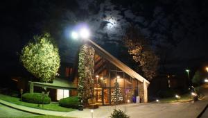 un edificio con un árbol de Navidad fuera de él por la noche en RiverBank Lodge, en Petersburg