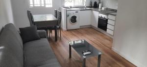 Una sala de estar con un sofá y una mesa y una cocina. en Villa Feli 3, en Benicàssim