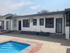 a house with a swimming pool in front of it at Golden View Boutique Guesthouse in Windhoek