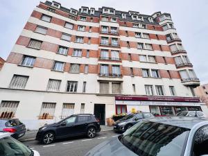 a large building with cars parked in front of it at Le Gentil Rooftop in Gentilly