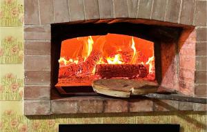 piec ceglany z ogniem w obiekcie Gorgeous Home In Carano With Kitchen w mieście Carano