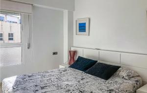 a white bedroom with a bed with blue pillows at Nice Apartment In El Campello With Wifi in El Campello
