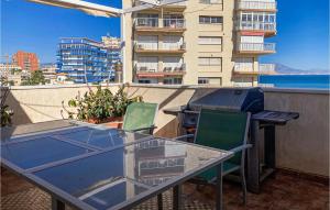 a glass table and chairs on a balcony with a building at Nice Apartment In El Campello With Wifi in El Campello +18 photos