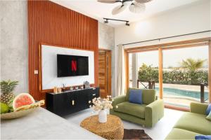 a living room with a tv and a couch and a chair at Kamili Villas, Bwejuu, Zanzibar in Bwejuu