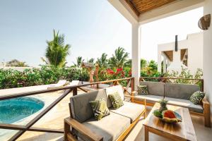 a patio with chairs and a pool on a balcony at Kamili Villas, Bwejuu, Zanzibar in Bwejuu