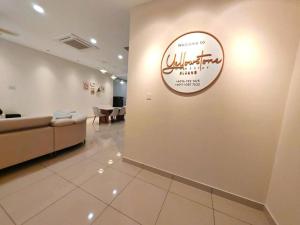 eine Lobby mit einer Couch und einem Schild an der Wand in der Unterkunft Yellowstone 13pax GatedGuarded KTV Games Kidslide in Keluang