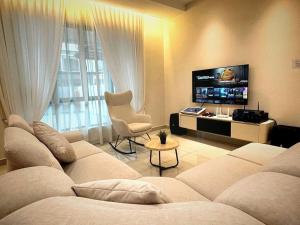 ein Wohnzimmer mit Couch und Flachbildfernseher in der Unterkunft Yellowstone 13pax GatedGuarded KTV Games Kidslide in Keluang