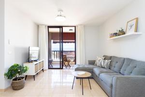 ein Wohnzimmer mit Sofa und Fernseher in der Unterkunft Home2Book Seaside Escape Playa La Arena in Puerto de Santiago