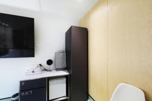 a black refrigerator in a room with a chair at Hotel RUGO in Jeonju