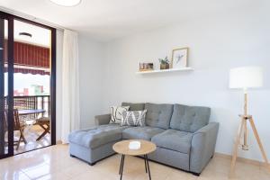 ein Wohnzimmer mit Sofa und Tisch in der Unterkunft Home2Book Seaside Escape Playa La Arena in Puerto de Santiago