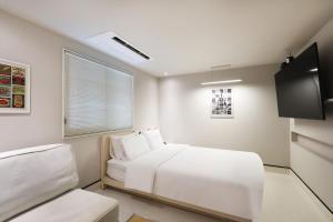 a bedroom with a white bed and a tv at Hotel RUGO in Jeonju +45 photos