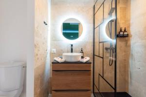 a bathroom with a sink and a mirror at The Jungle - Jacuzzi, Sauna & Projector in Cannes