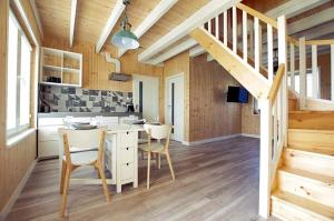 a kitchen with a table and chairs and a staircase at Domy Solmare in Jantar