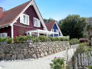 ein rotes Haus mit einer Stützmauer aus Stein in der Unterkunft Küstenhaus Koserow in Ostseebad Koserow