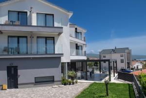 a white house with a patio and a balcony at Pansion Leggero in Krk