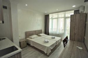 Un dormitorio con una cama y una ventana grande. en A cozy apartments, en Batumi