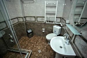 un baño con inodoro y lavabo en A cozy apartments, en Batumi