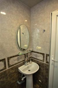 un baño con lavabo y espejo en A cozy apartments, en Batumi