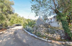 a house with a stone wall next to a road at Trullo 1474 in Ceglie Messapica