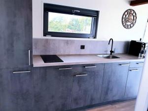 una cucina con un lavandino e una finestra di Houseboat Isola a Monnickendam