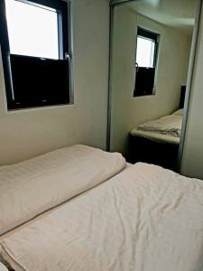 2 letti in una stanza con due specchi di Houseboat Isola a Monnickendam
