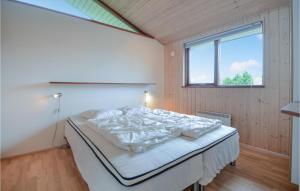 a bedroom with a bed in a room with a window at Holiday Home Valmuevej Rønde Ix in Rønde
