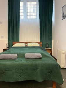 a large green bed with two pillows on it at TomTom Hostel in Krakow