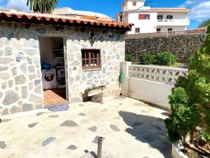 una casa de piedra con patio y valla en Casa El Pajero, en Breña Alta