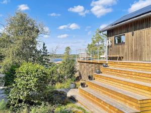 dom z drewnianym tarasem obok budynku w obiekcie 4 star holiday home in VÄDDÖ w mieście Väddö +24 zdjęcia