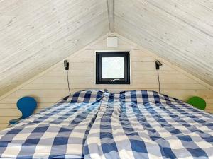 sypialnia z łóżkiem w niebiesko-białą kratkę na poddaszu w obiekcie 4 star holiday home in VÄDDÖ w mieście Väddö