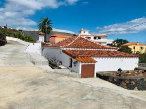 a white house with a red tile roof at Casa El Pajero in Breña Alta