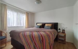 Un dormitorio con una cama grande con una manta colorida. en Nice House In Putten, en Putten
