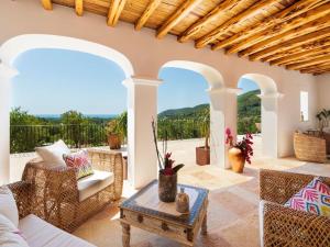an outdoor patio with chairs and a table at Holiday home with children play area in Santa Eularia des Riu