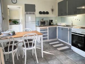 una cucina con tavolo in legno ed elettrodomestici bianchi di 4 person holiday home in FÄRJESTADEN a Färjestaden