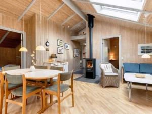 a living room with a table and chairs and a fireplace at 4 star holiday home in Nysted in Nysted