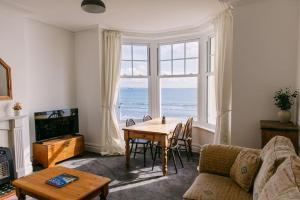a living room with a table and a large window at Dream Beach View in Weymouth