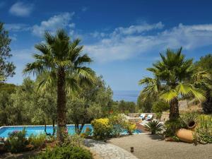 a resort with a swimming pool and palm trees at Holiday home with spacious lounge area in Banyalbufar