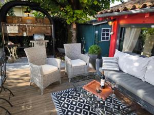 Un patio con un sofá y sillas y una mesa. en Le Jardin Villemaurine, en Saint-Émilion