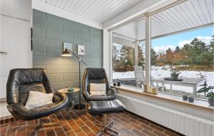 two black leather chairs in a room with a window at Holiday Home Sandtoftevej Blåvand Ix in Blåvand