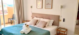 ein Schlafzimmer mit einem Bett mit zwei Stofftieren darauf in der Unterkunft Relax Oasis del Mar in Puerto de Santiago