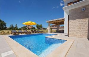 a swimming pool with chairs and an umbrella next to a house at Villa Fortuna in Funtana +32 photos