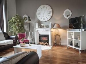 a living room with a fireplace and a clock on the wall at La Villa Côté Cour in Dinan +23 photos