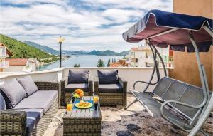 eine Terrasse mit Stühlen, Sonnenschirm und Tisch in der Unterkunft Four-Bedroom Apartment In Klek in Klek