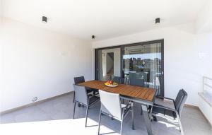 une salle à manger avec une table et des chaises en bois dans l'établissement Beautiful Home In Seget Vranjica, à Seget Vranjica