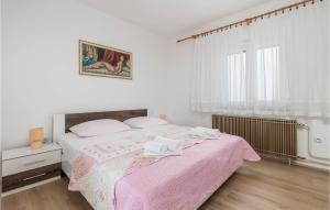 une chambre avec un lit avec une couverture rose dans l'établissement 2 Bedroom Stunning Home In Sveti Juraj, à Sveti Juraj 19 autres photos