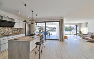 une cuisine et un salon avec un comptoir et des chaises dans l'établissement Beautiful Home In Seget Vranjica, à Seget Vranjica