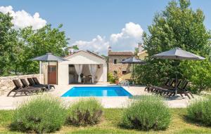 een zwembad met 2 stoelen en parasols bij Casa Ida in Grožnjan